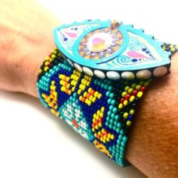 Pulsera tejida con chaquira y ojo de madera pintado a mano