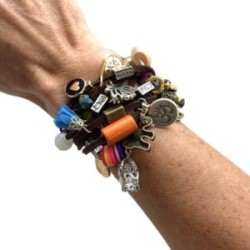 Pulsera de Gamuza con dijes de diferentes metales, flecos, muñequitas y flores café